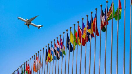 jet flying over international flags